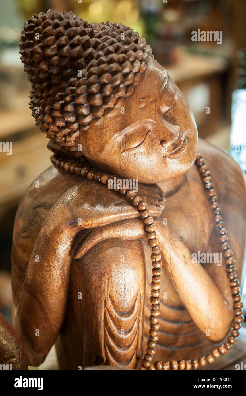 Buddah wooden statue, sitting in meditation with eyes closed and bended head. Stock Photo