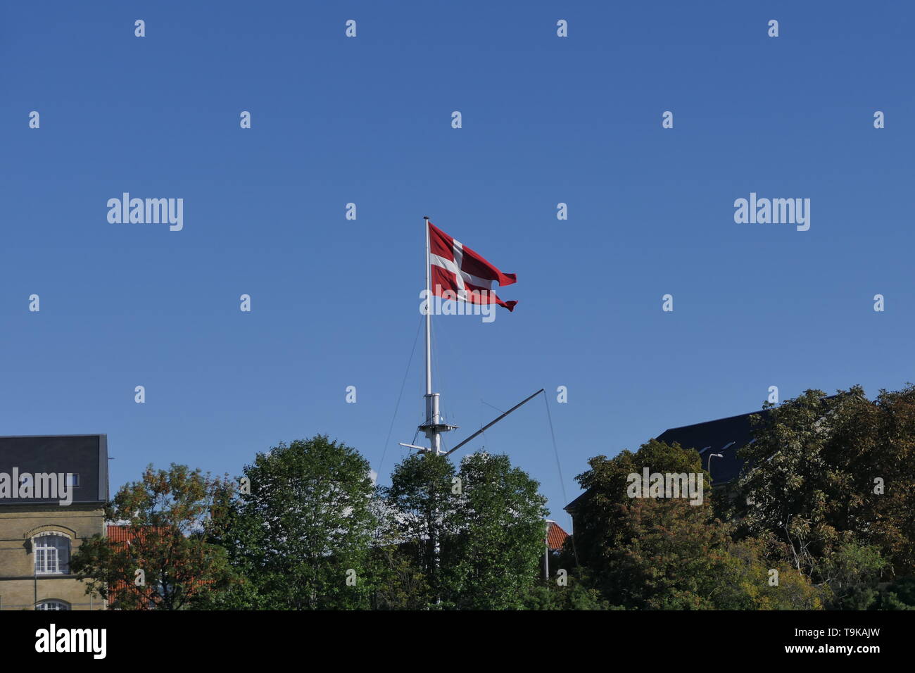 The national flag of Denmark on a mast at the Copenhagen harbor, Denmark Stock Photo