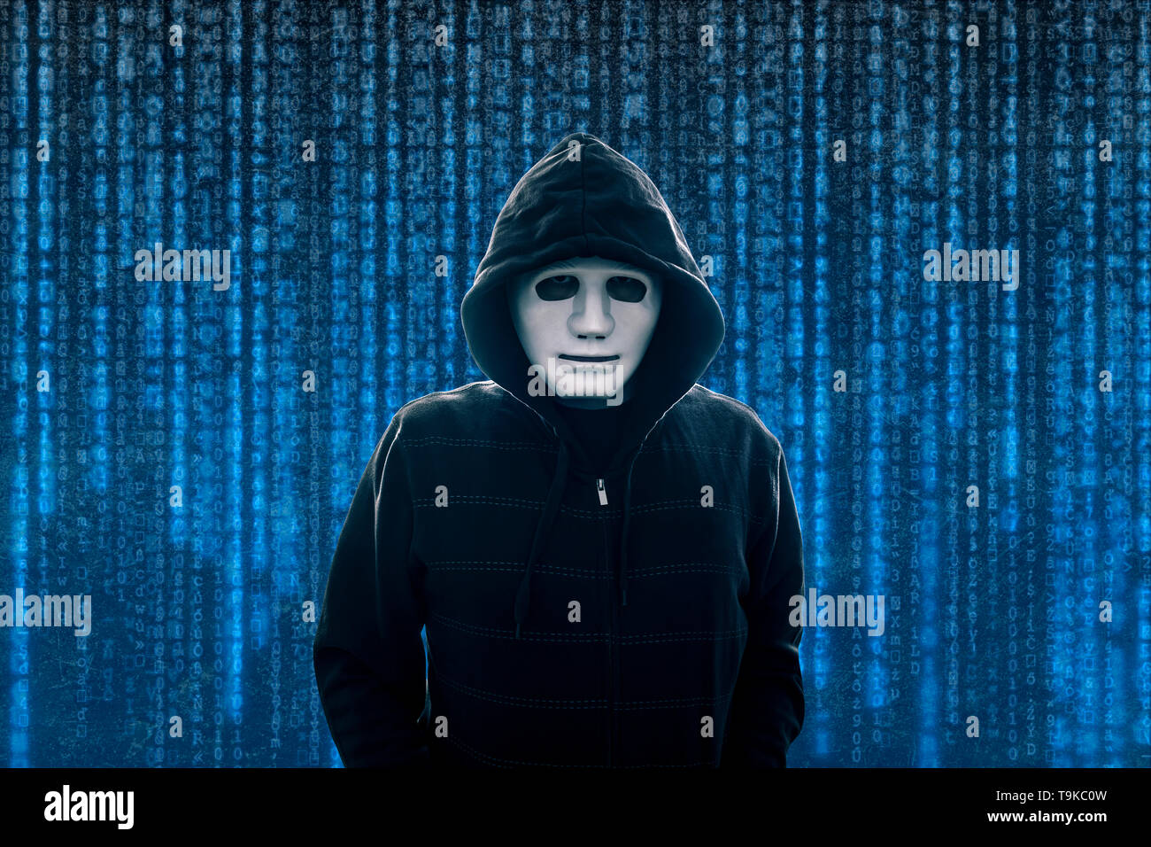 Hooded computer hacker with white mask Stock Photo