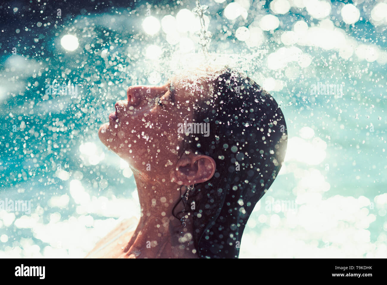 water drops on face of young woman. water bathing in swimming pool