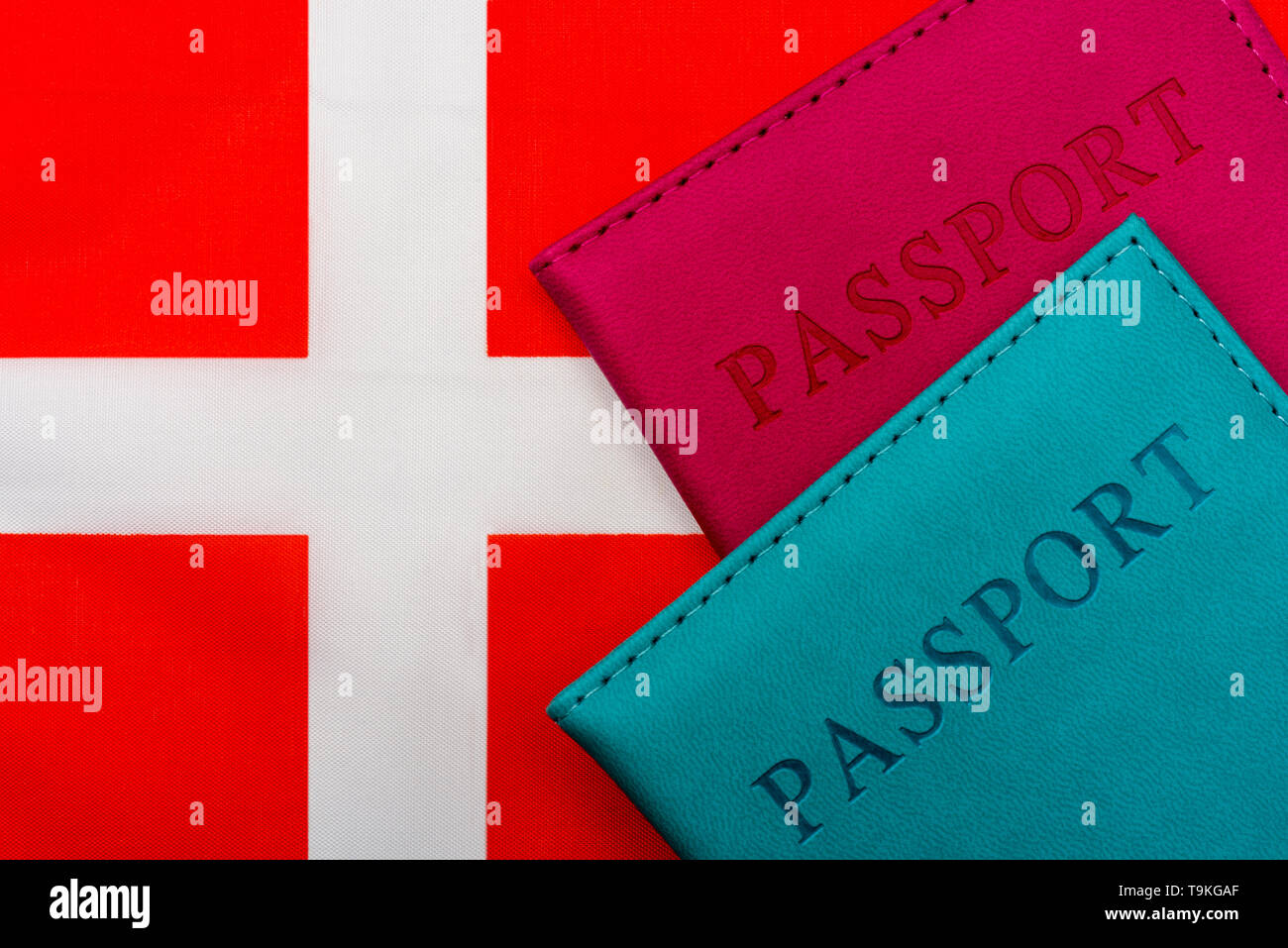 On the flag of Denmark is a passport. The concept of travel and tourism to foreign countries. Stock Photo