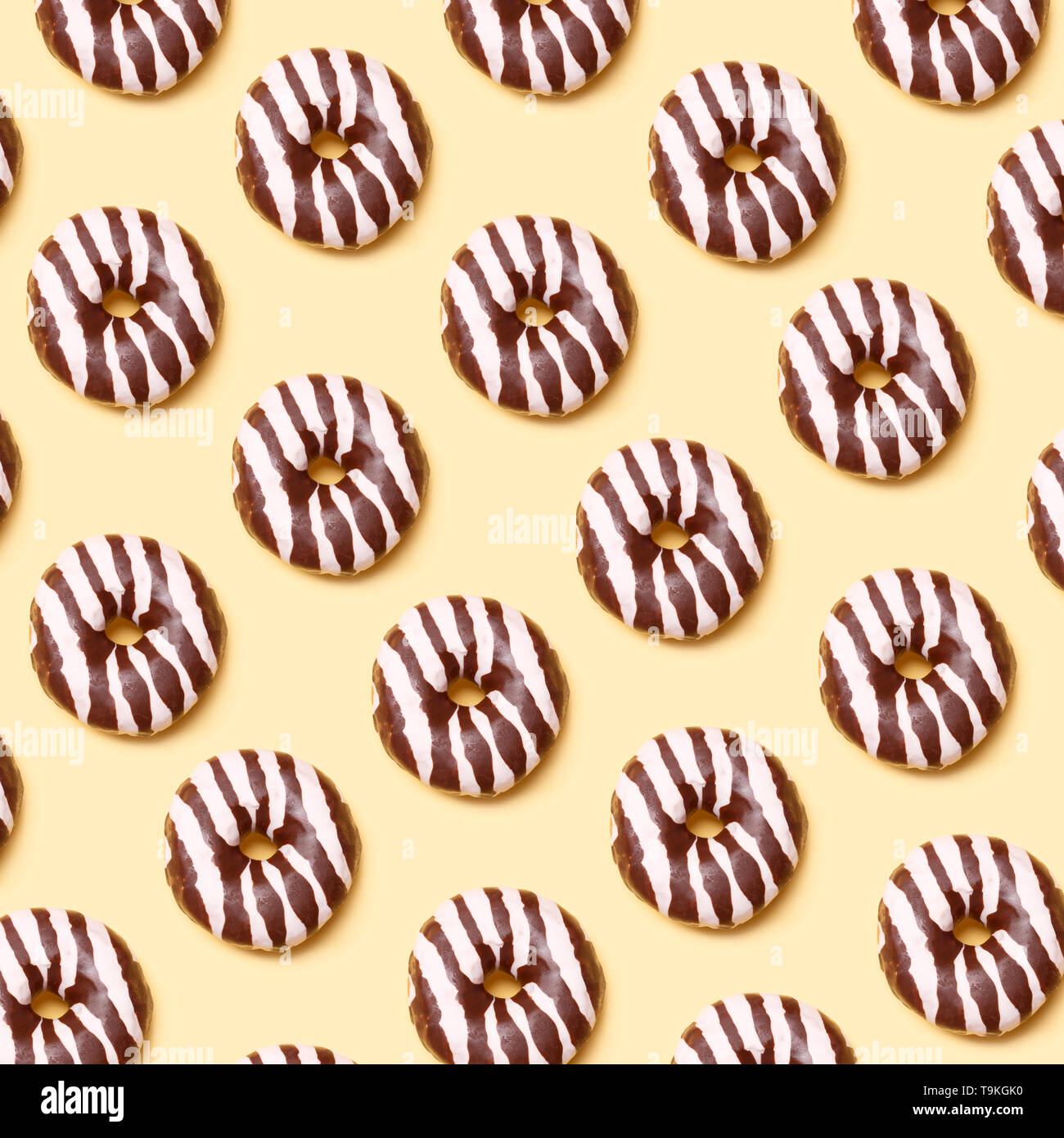 Chocolate donuts pattern on yellow background Stock Photo