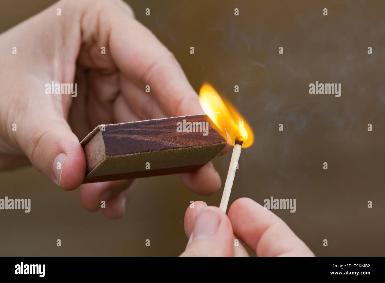 hands striking a match on blurred background, closeup Stock Photo
