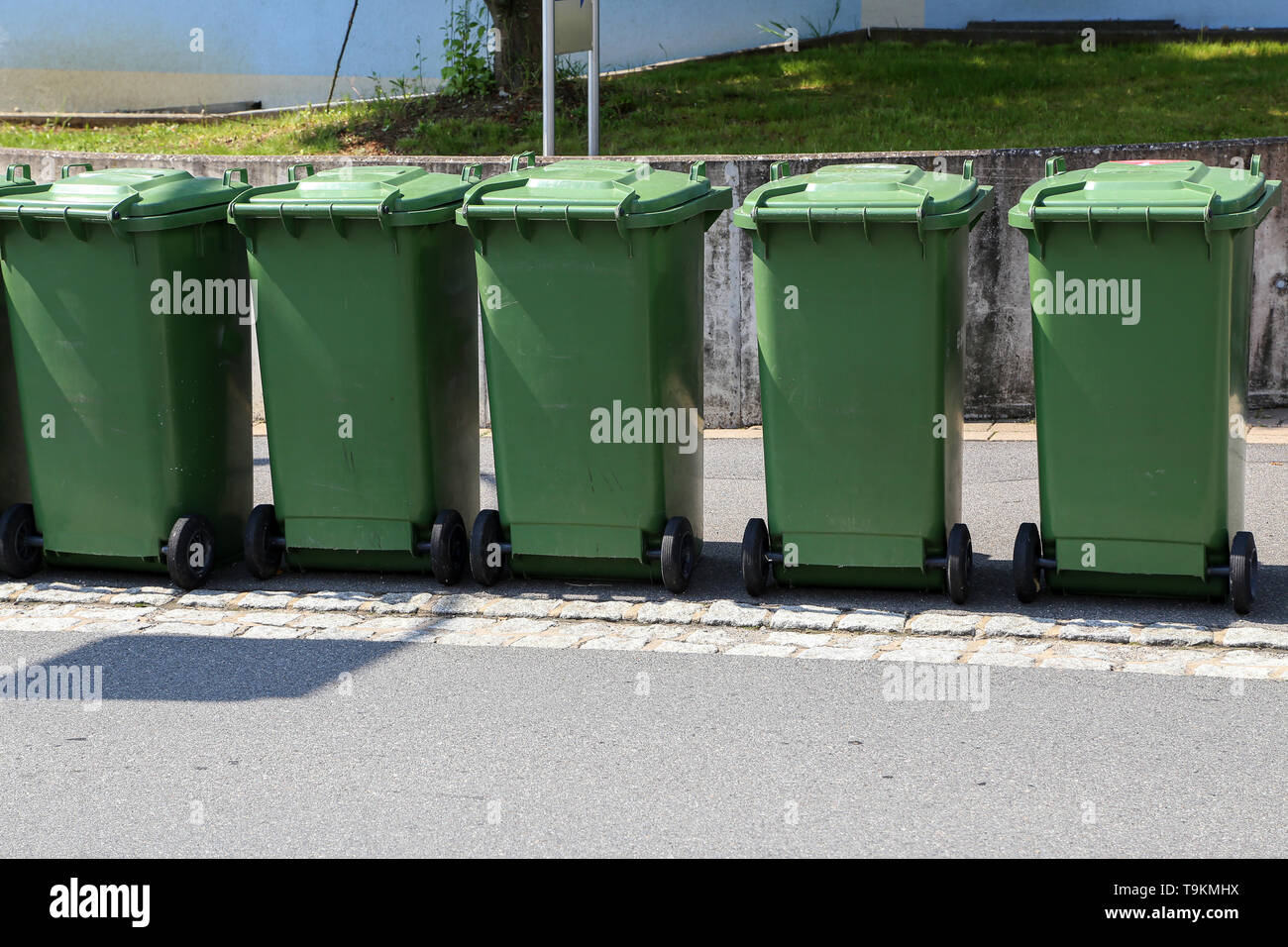 Green garbage cans are on the street Stock Photo Alamy