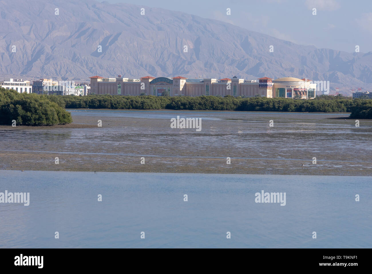 Ras al Khaimah Mall across the Corniche towards the mountains in the afternoon sun. Stock Photo