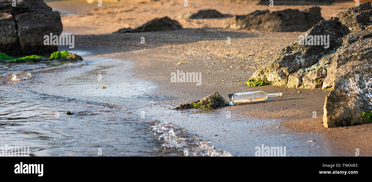 Message in a corked bottle on the shore, hope of salvation Stock Photo