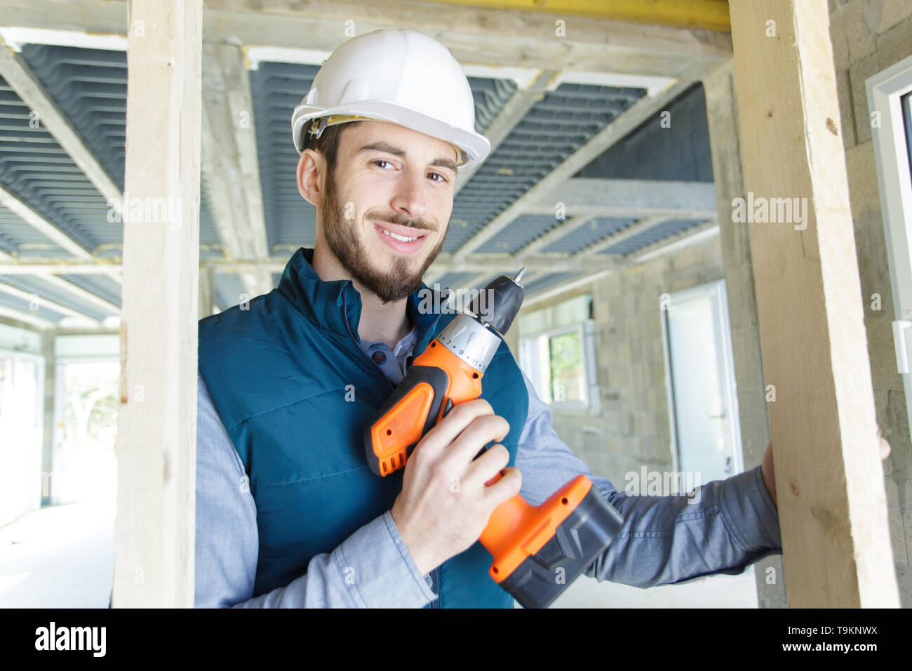 portrait of young male carpenter holding cordless power tool Stock Photo