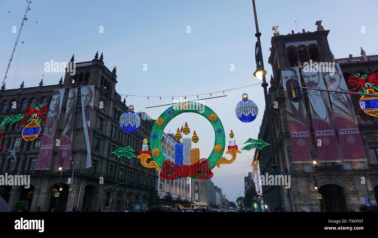 Christmas lights and decorations with Gobierno de Mexico banners of historical figures, Plaza de la Constitucion, Zocalo, Mexico City. Stock Photo