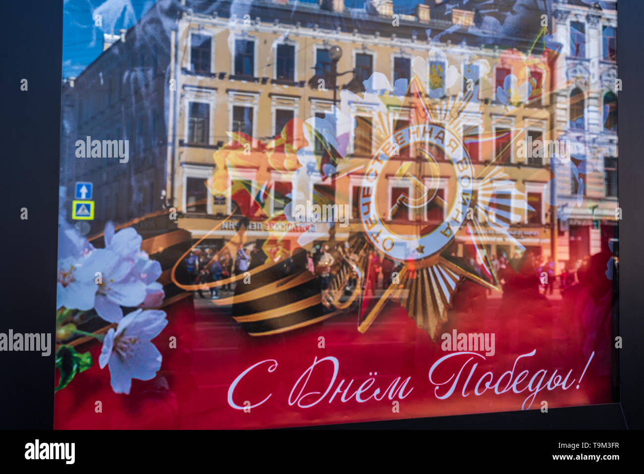 Reflection of a poster  of the Victory Day with Nevsky prospekt parade in the background. St Petersburg, Russia. Stock Photo