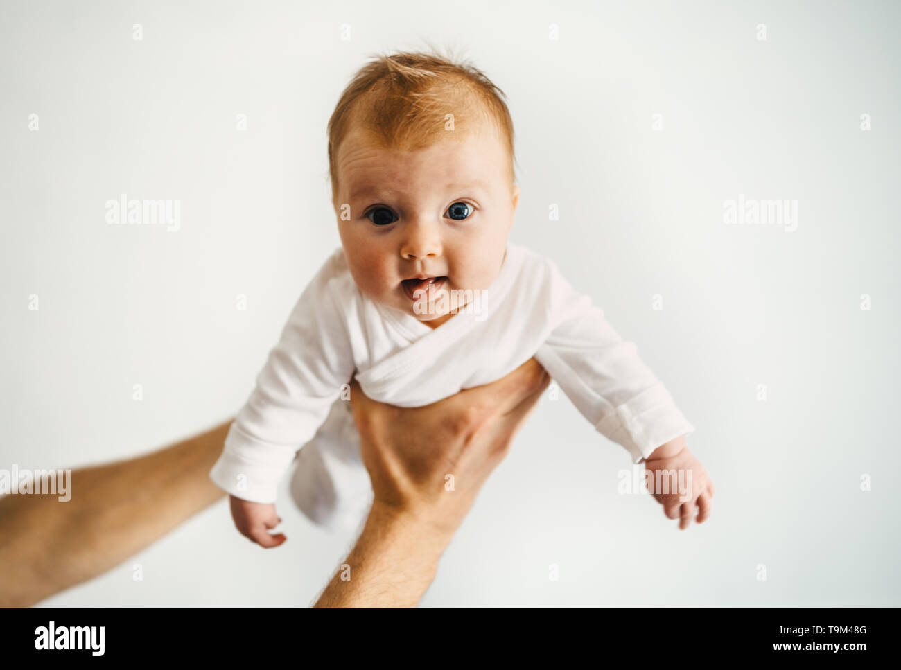 Baby in father hands family lifestyle dad playing with child infant parenthood concept Stock Photo