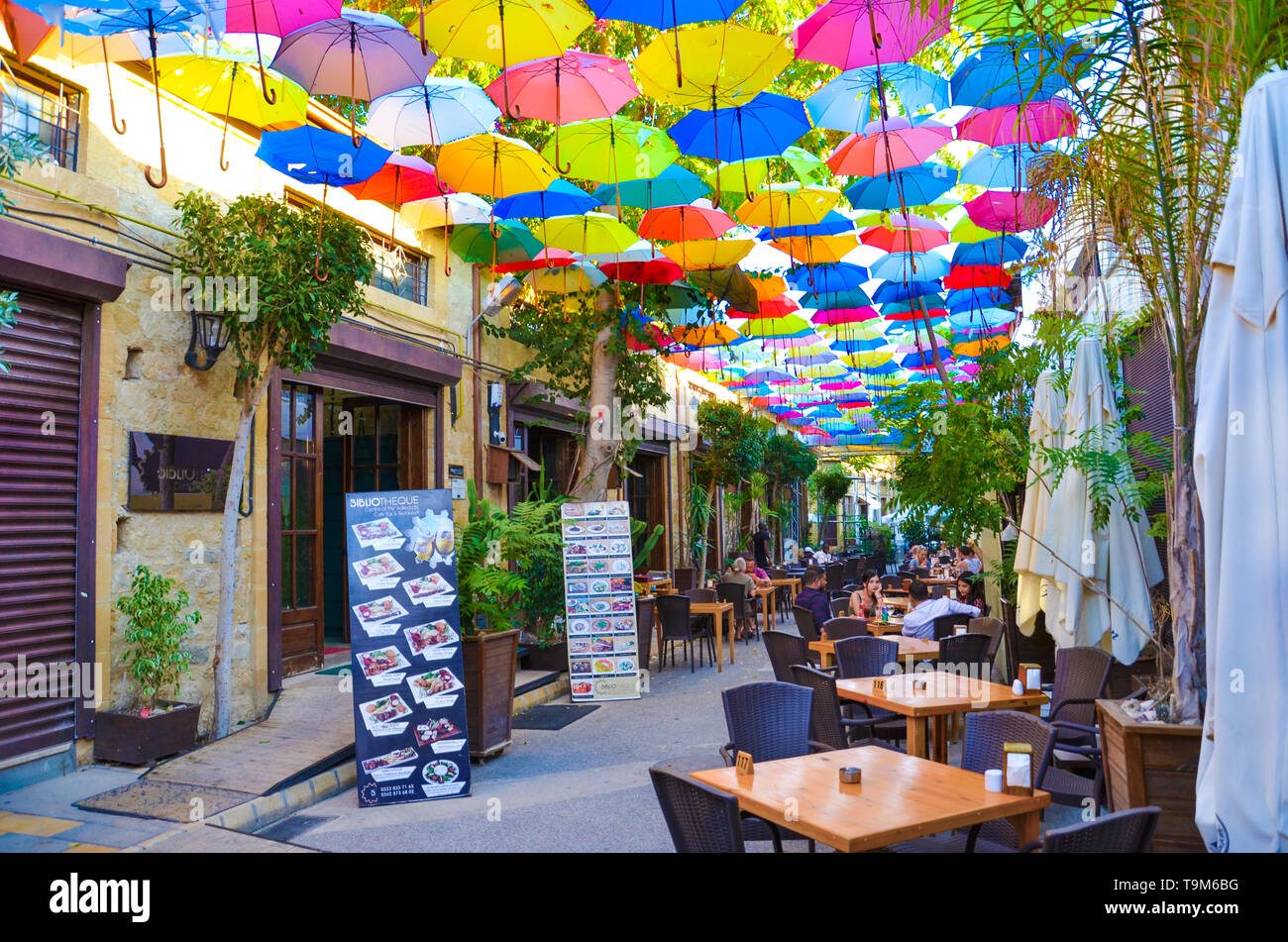 Nicosia, Cyprus - Oct 4th 2018: Outdoor cafe with amazing colorful umbrellas decorating the top of the street. Popular tourist spot in the city center Stock Photo