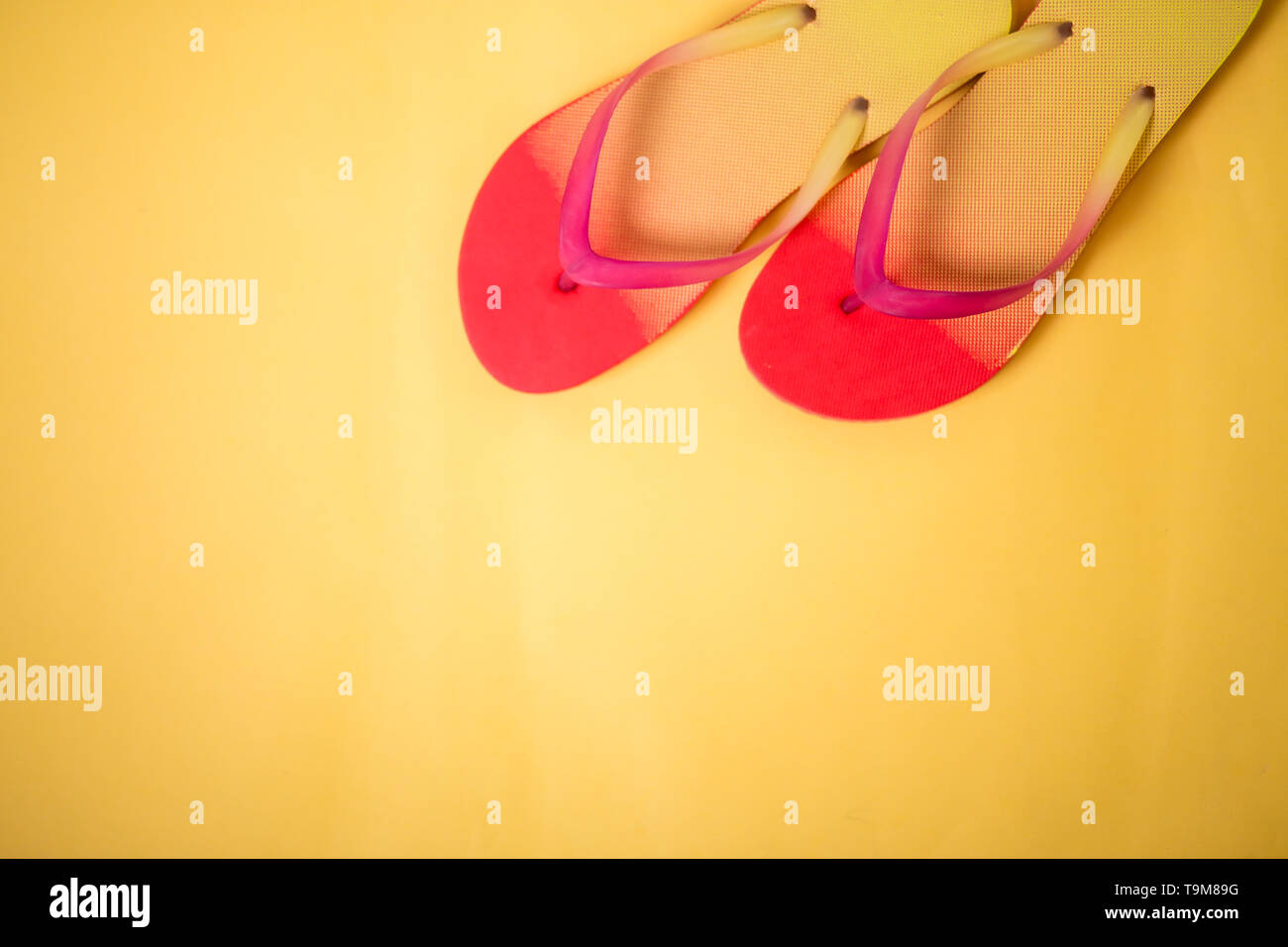 Coral pink sandals on yellow background with copy space. Flat lay ...