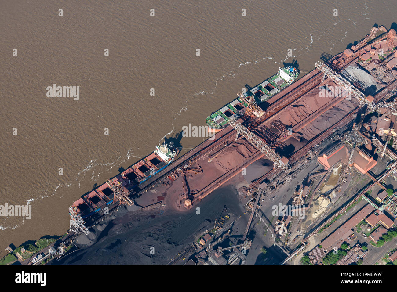 aerial image of cargo vessels loading on the Parana River at Muelle Carbon Siderar in the port of Barrio 7 de Septiembre, San Nicolás de los Arroyos,  Stock Photo