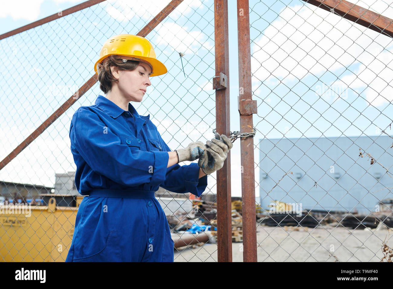 Female Worker Opening Gate Stock Photo