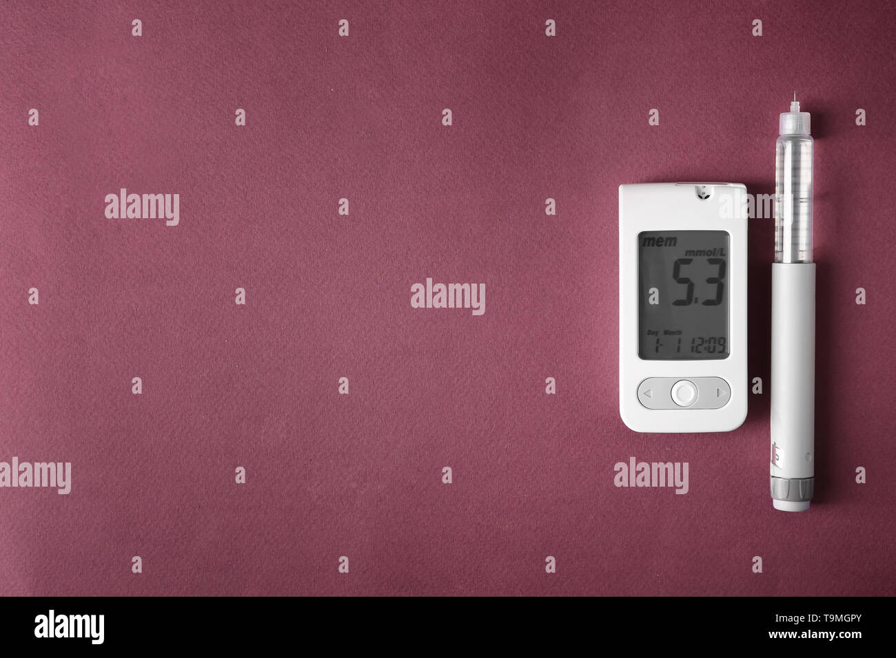 Digital glucometer with syringe on color background. Diabetes control