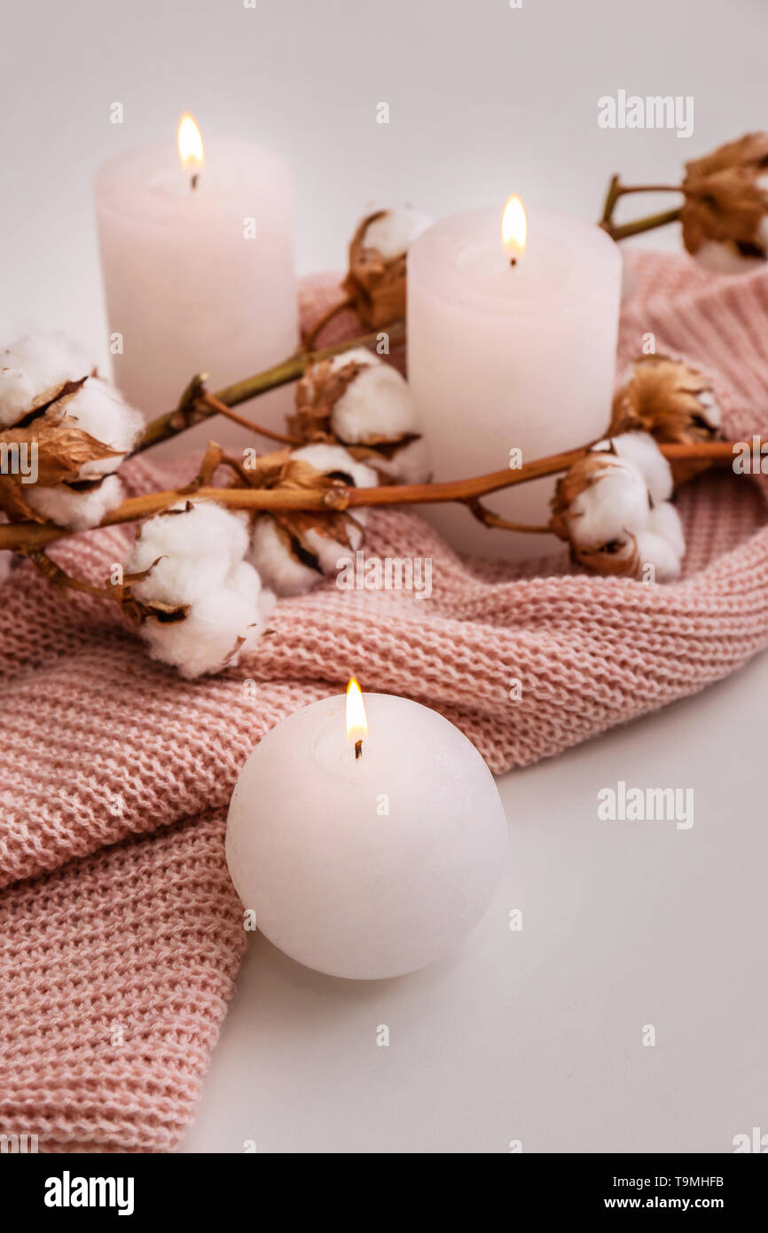Composition with burning candles and cotton flowers on white background ...