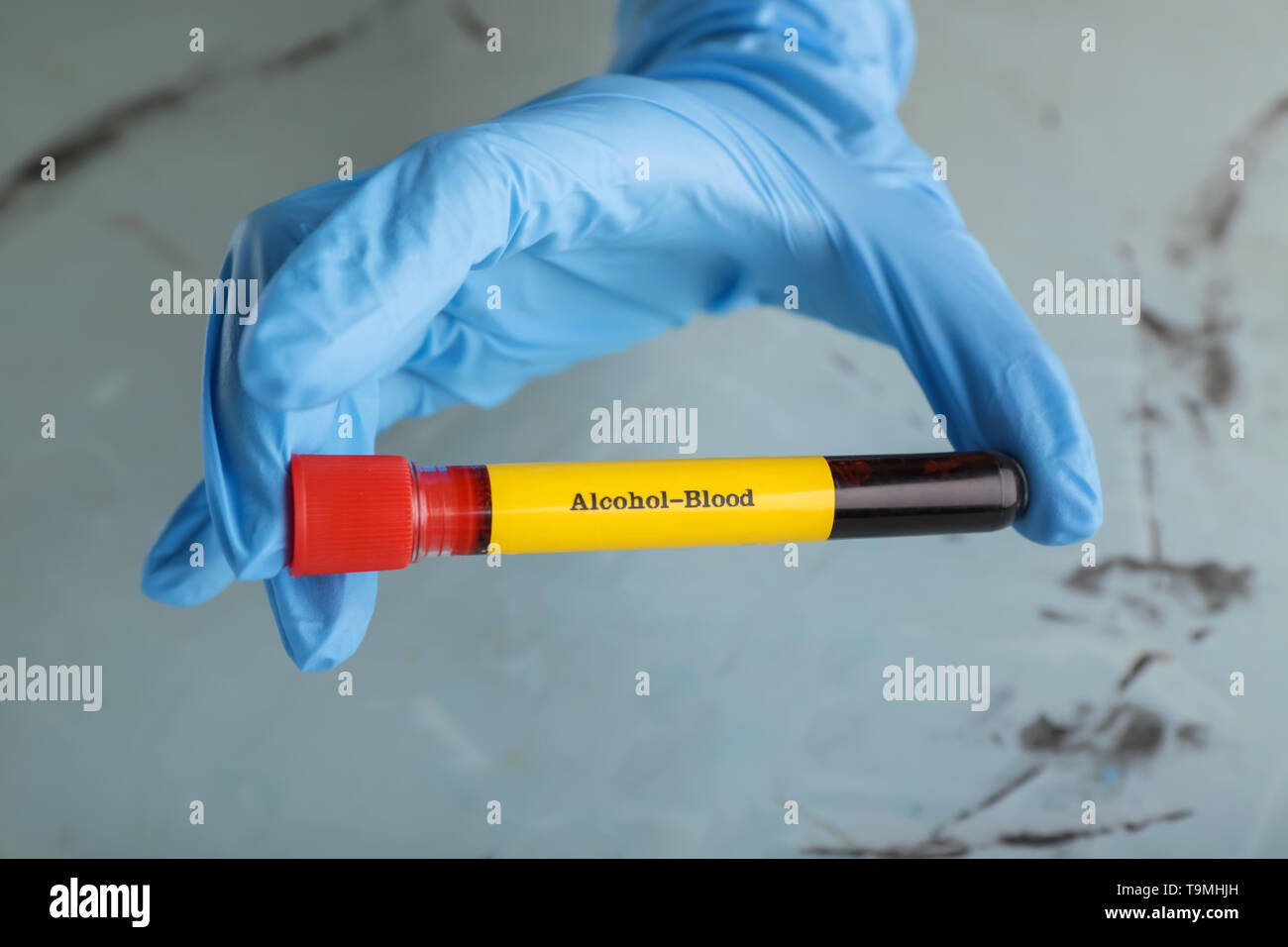 Medical worker holding test tube with blood of drunk person on light