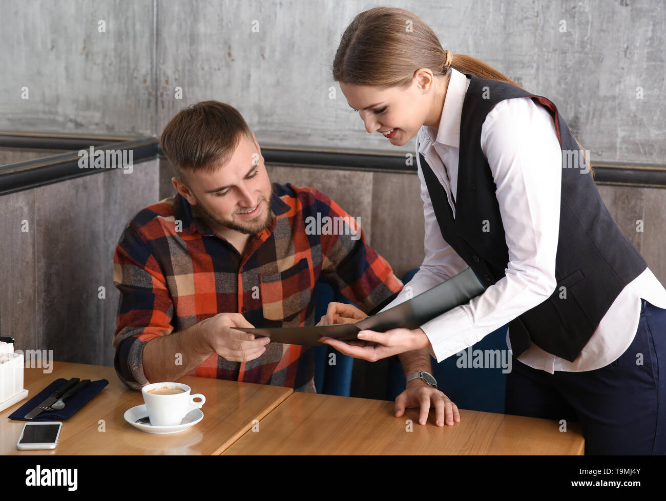 Waitressing Man Young waitress showing man a menu in restaurant Stock Photo - Alamy