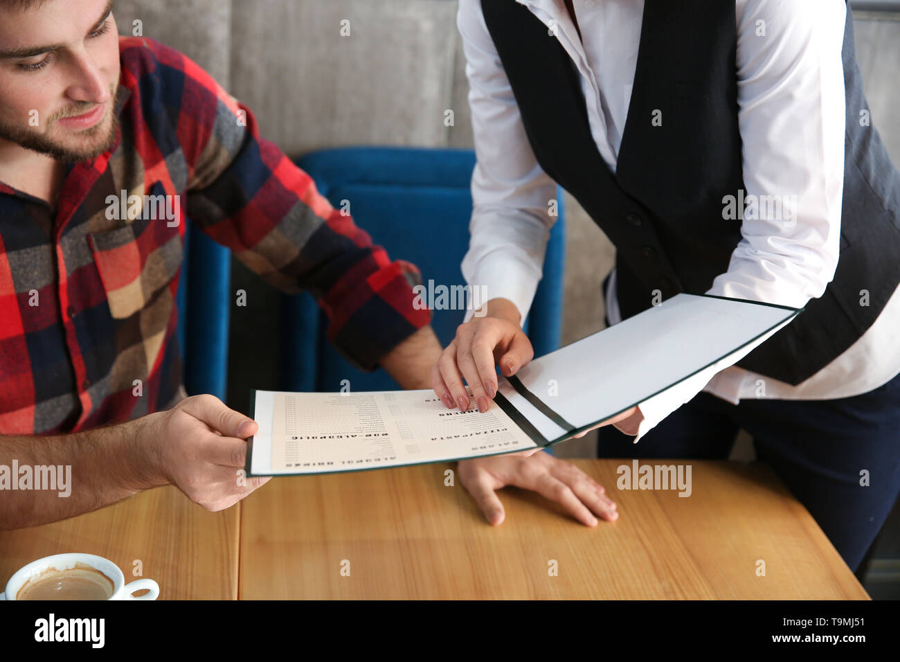 Waitressing Man Young waitress showing man a menu in restaurant Stock Photo - Alamy