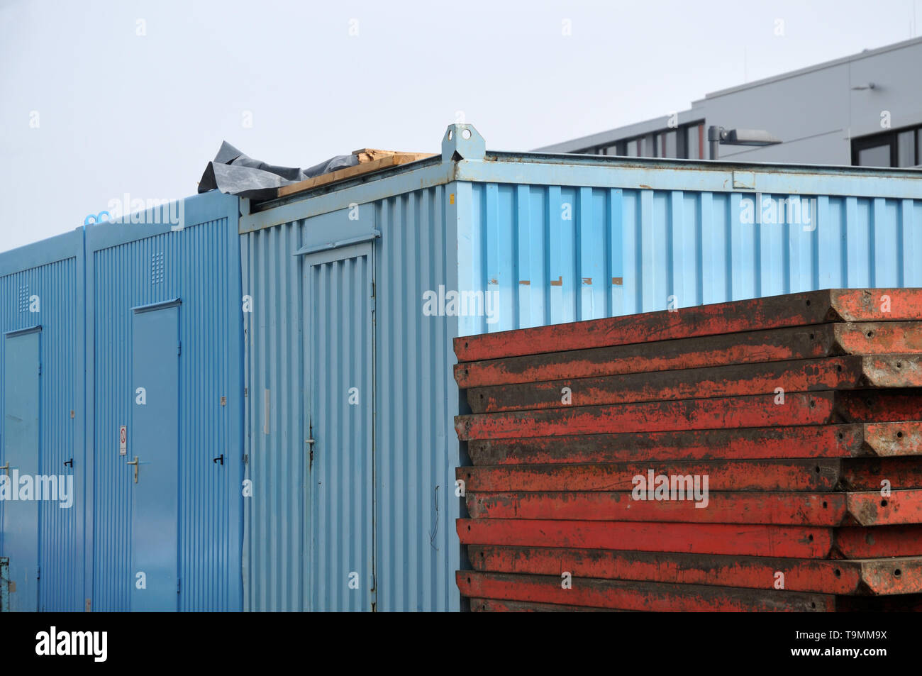 metal containers and stacked formwork elements at large construction