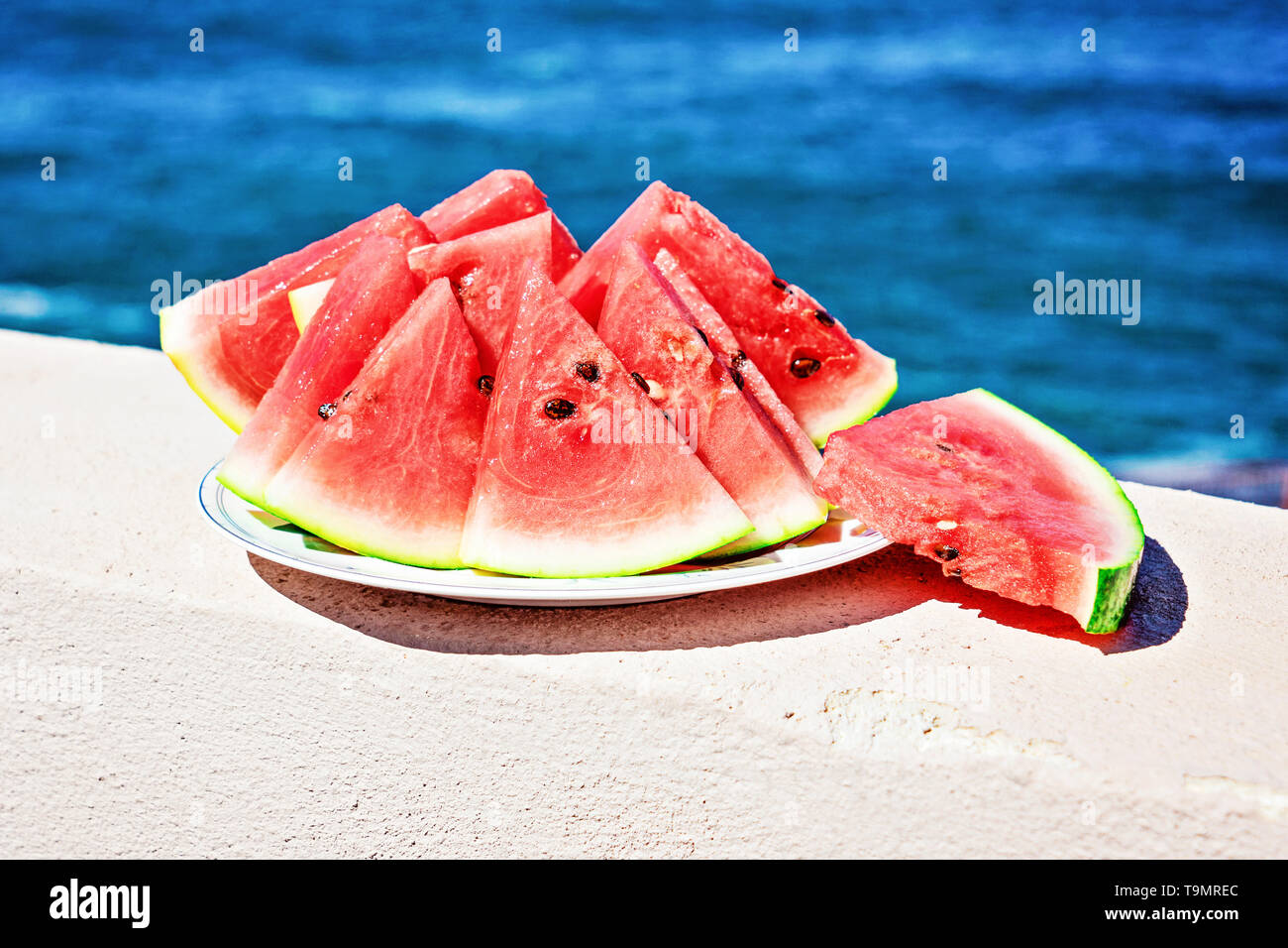 Pieces of ripe watermelon cut into triangles on the blue sea background ...