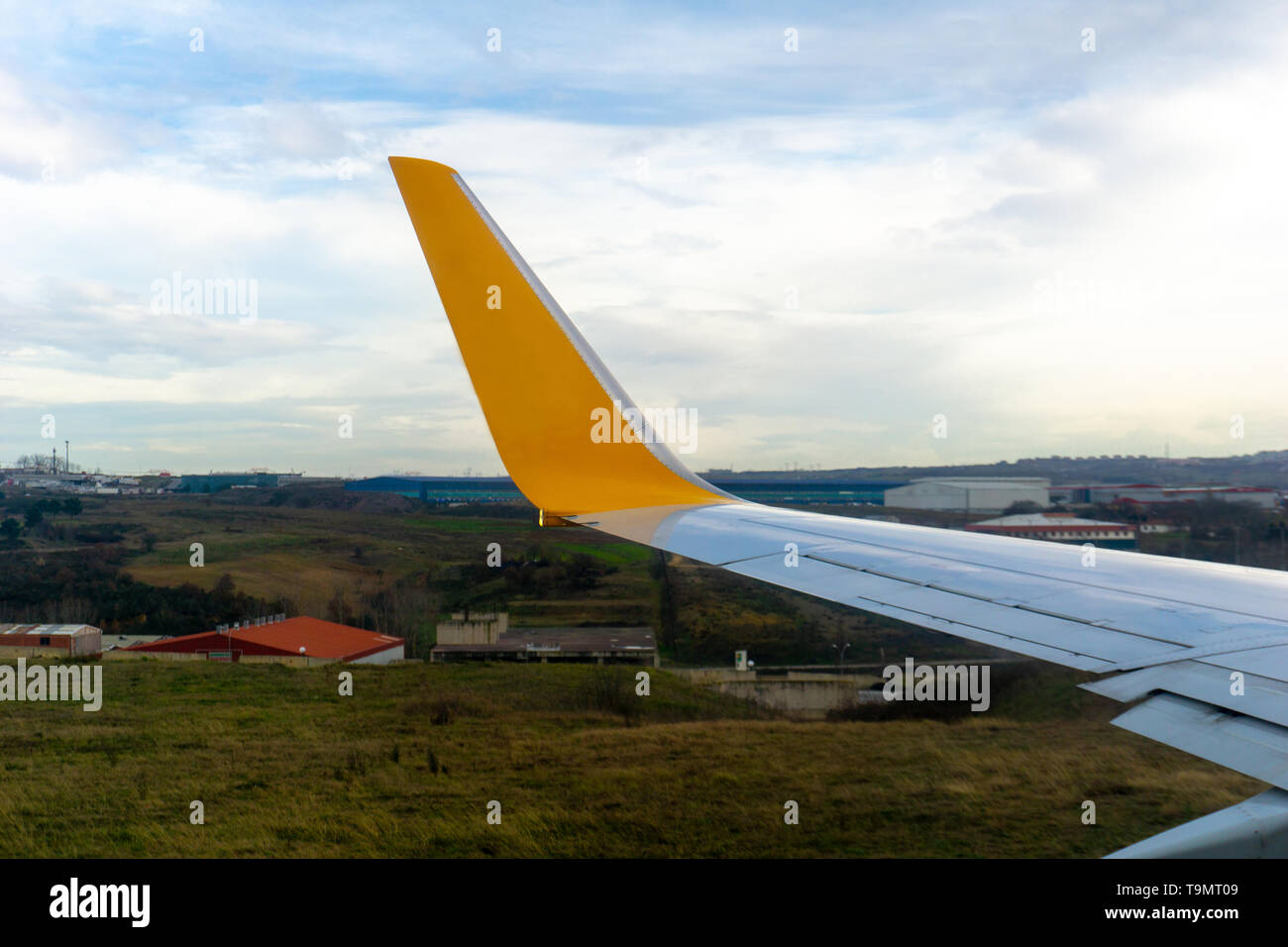 Green grassland seen through window of an taxiing aircraft, airplane wing from window. Stock Photo