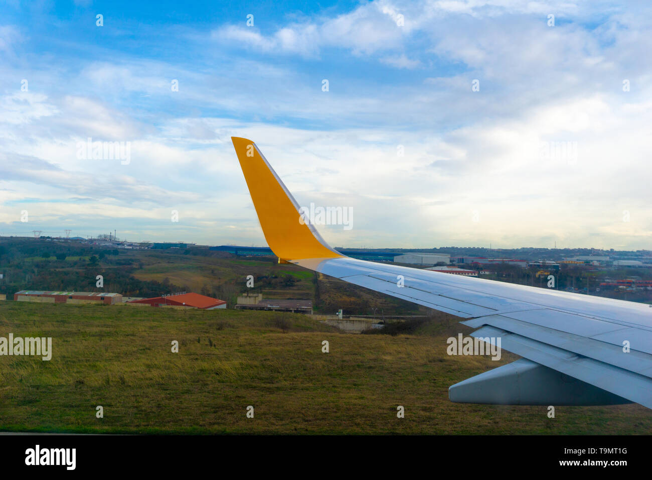 Green grassland seen through window of an taxiing aircraft, airplane wing from window. Stock Photo