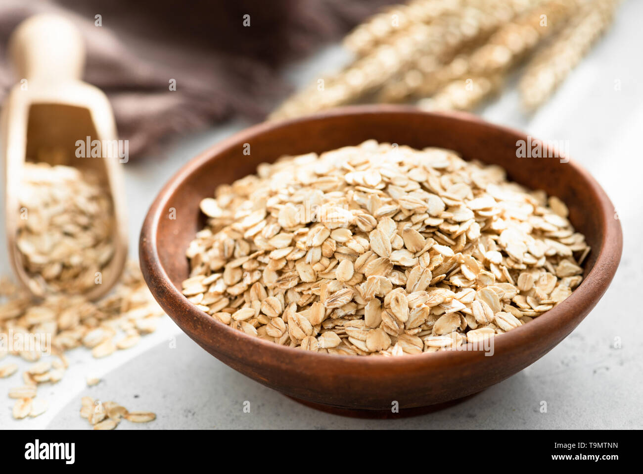 Oat flakes, rolled oats in bowl. Dry breakfast cereals. Healthy eating, healthy lifestyle concept Stock Photo