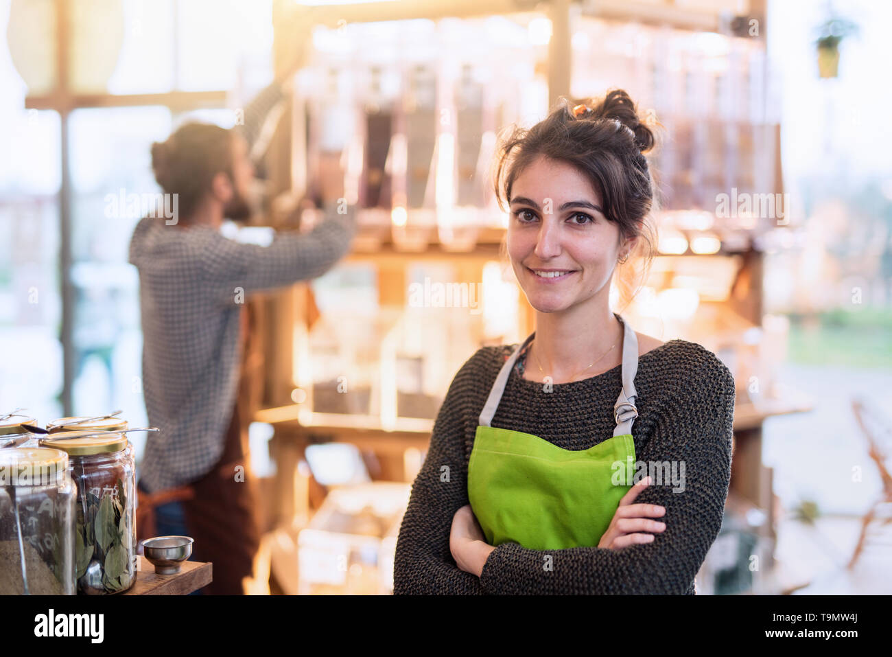 Portrait of a young woman arms crossed, owner of her food store.  Stock Photo