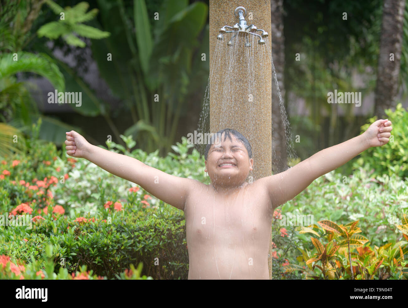 Happy obese boy taking shower before swimming, healthy and recreation