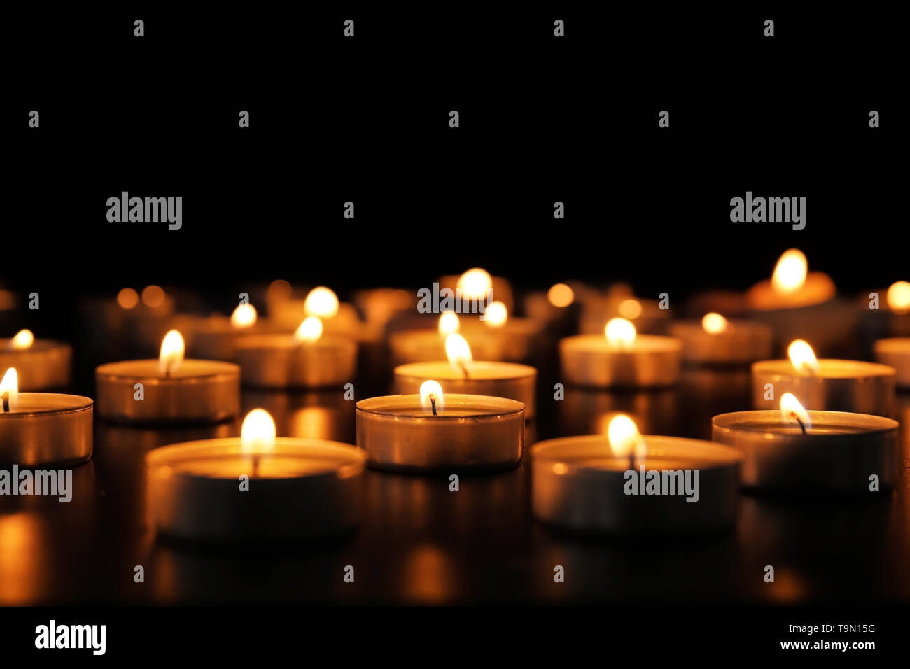 Burning candles on dark background Stock Photo - Alamy