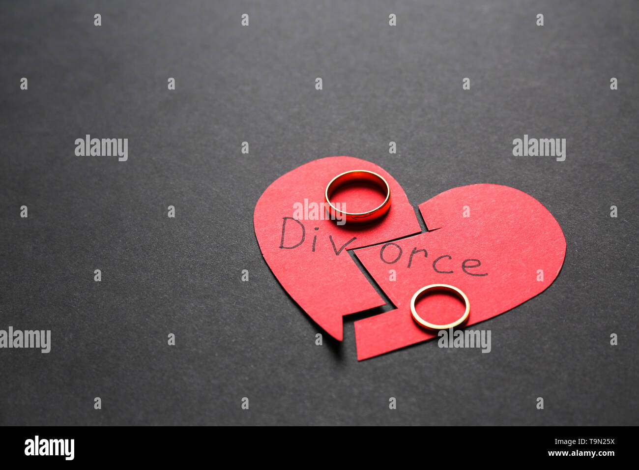 Broken red heart with rings on dark background. Concept of divorce ...