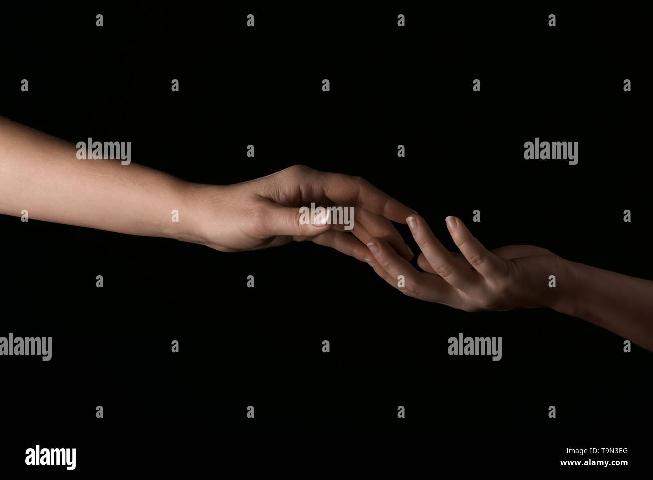 Female hands touching fingers on dark background Stock Photo - Alamy