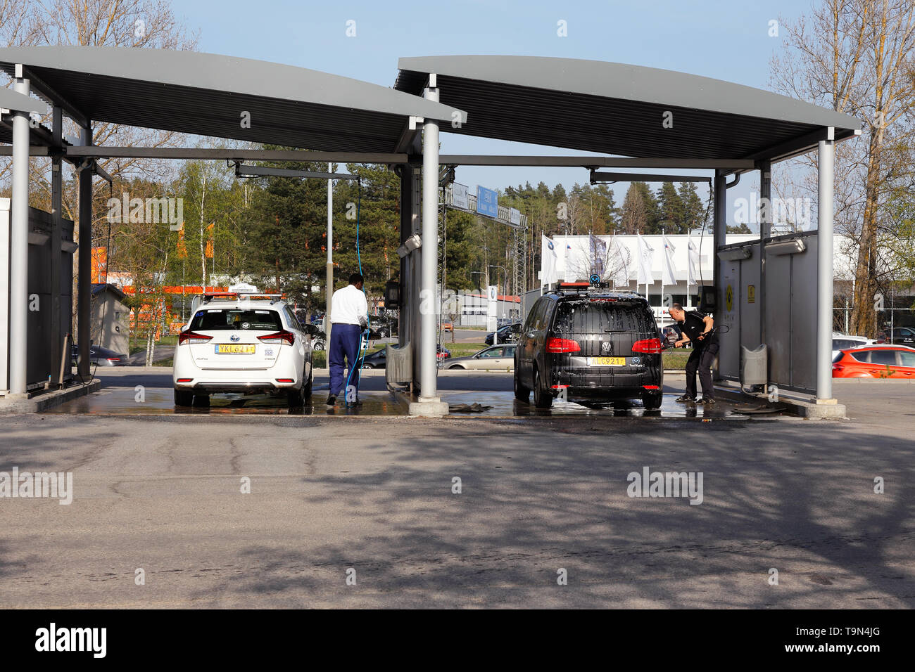 Orebro, Sweden - April 26, 2019: Two taxis and two persons washing enviroment friendly at the self service car wash. Stock Photo