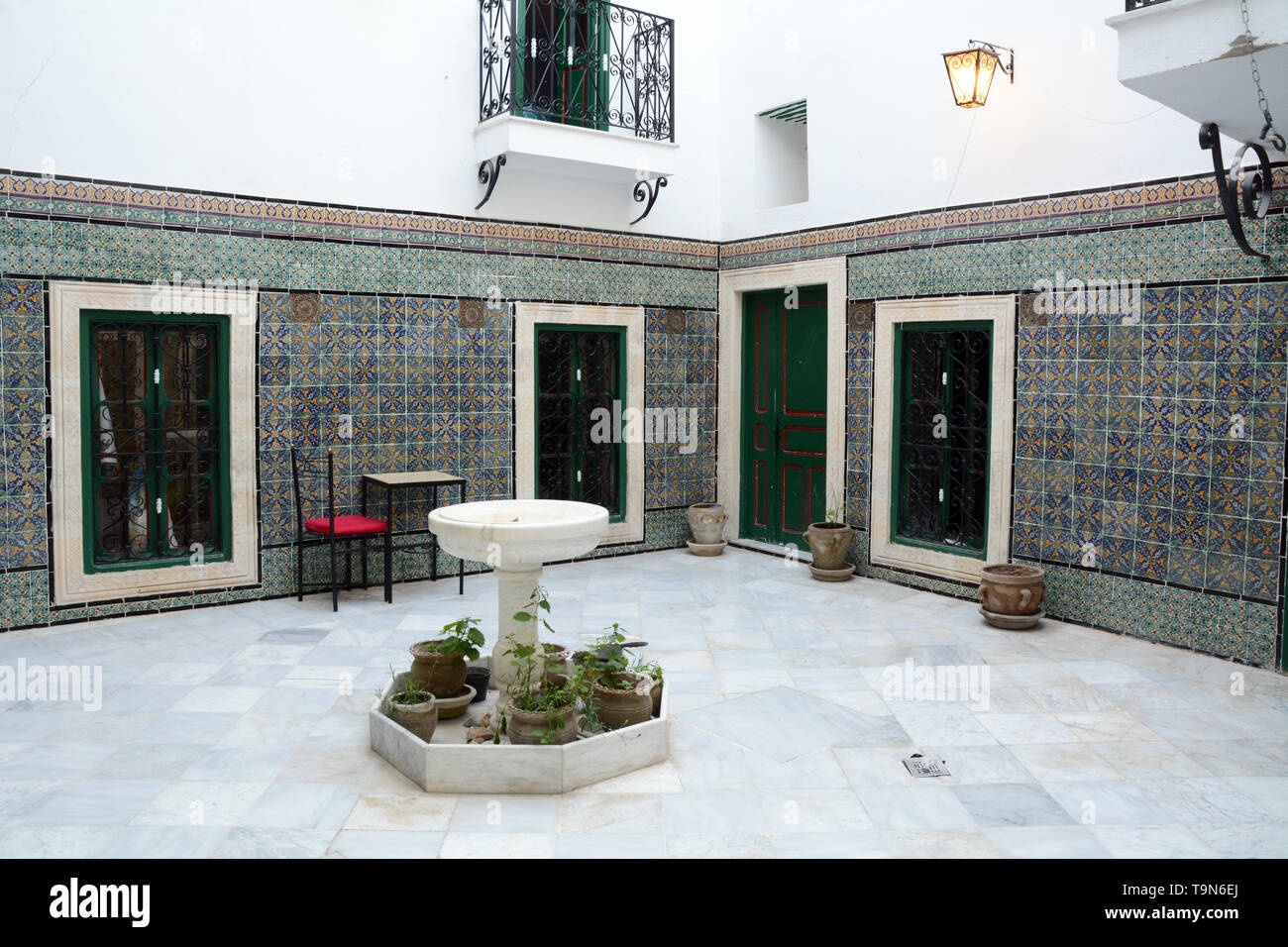 Islamic architectural motifs and tile work in the open-air courtyard of a traditional 16th century home in the medina (old city) of Tunis, Tunisia. Stock Photo