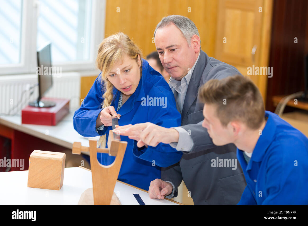 carpenter with students in woodworking workshop Stock Photo