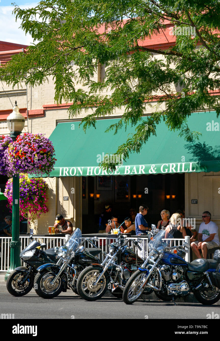 Motorcycles parked in front of the outside dining area of The Iron Horse Bar and Grill, a longtime hangout in downtown Coeur d'Alene, ID Stock Photo