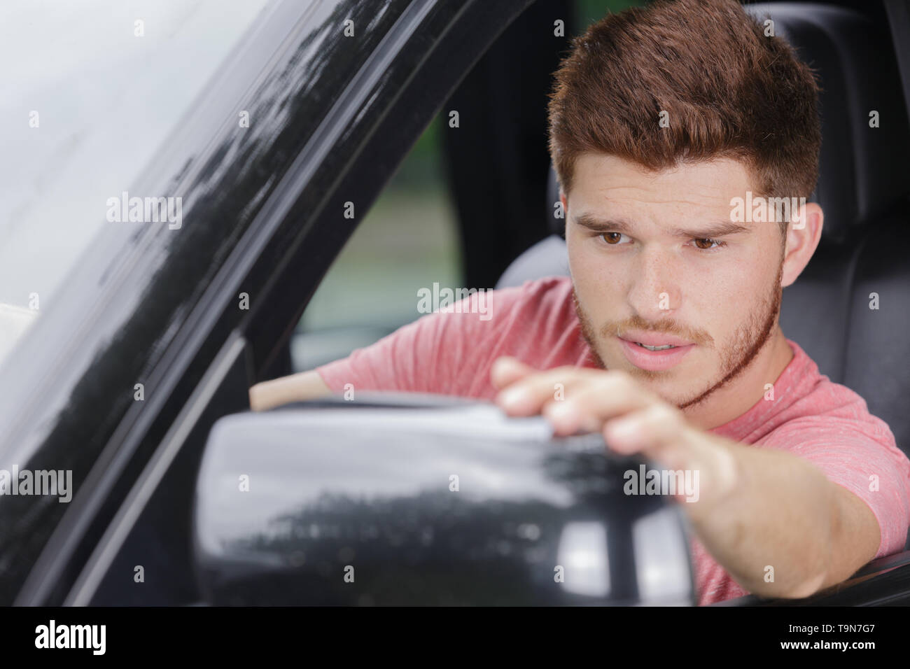 male correcting side mirror in car Stock Photo Alamy