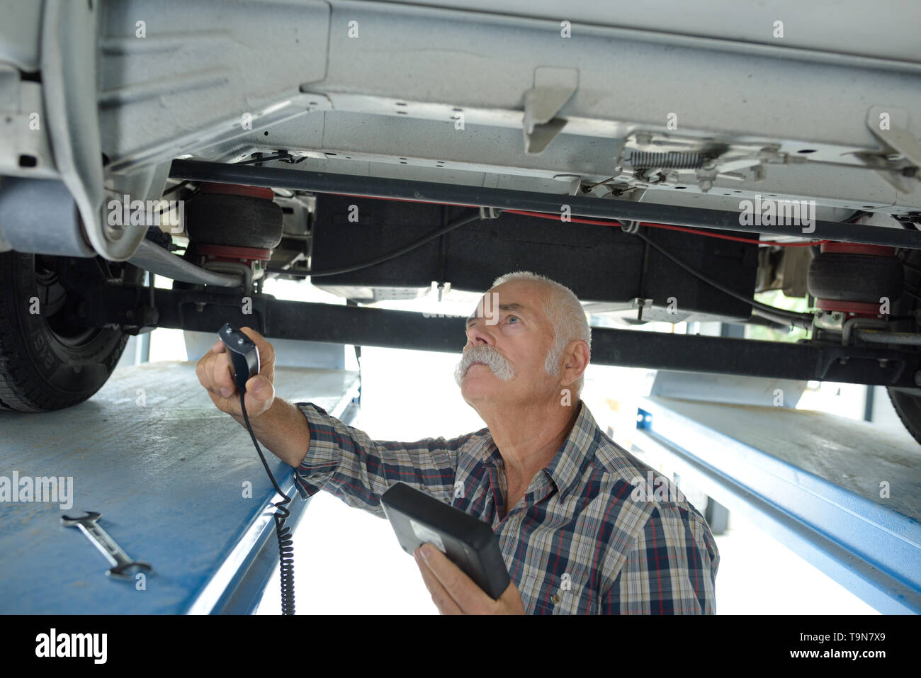 senior mechanic working underneath a car Stock Photo Alamy