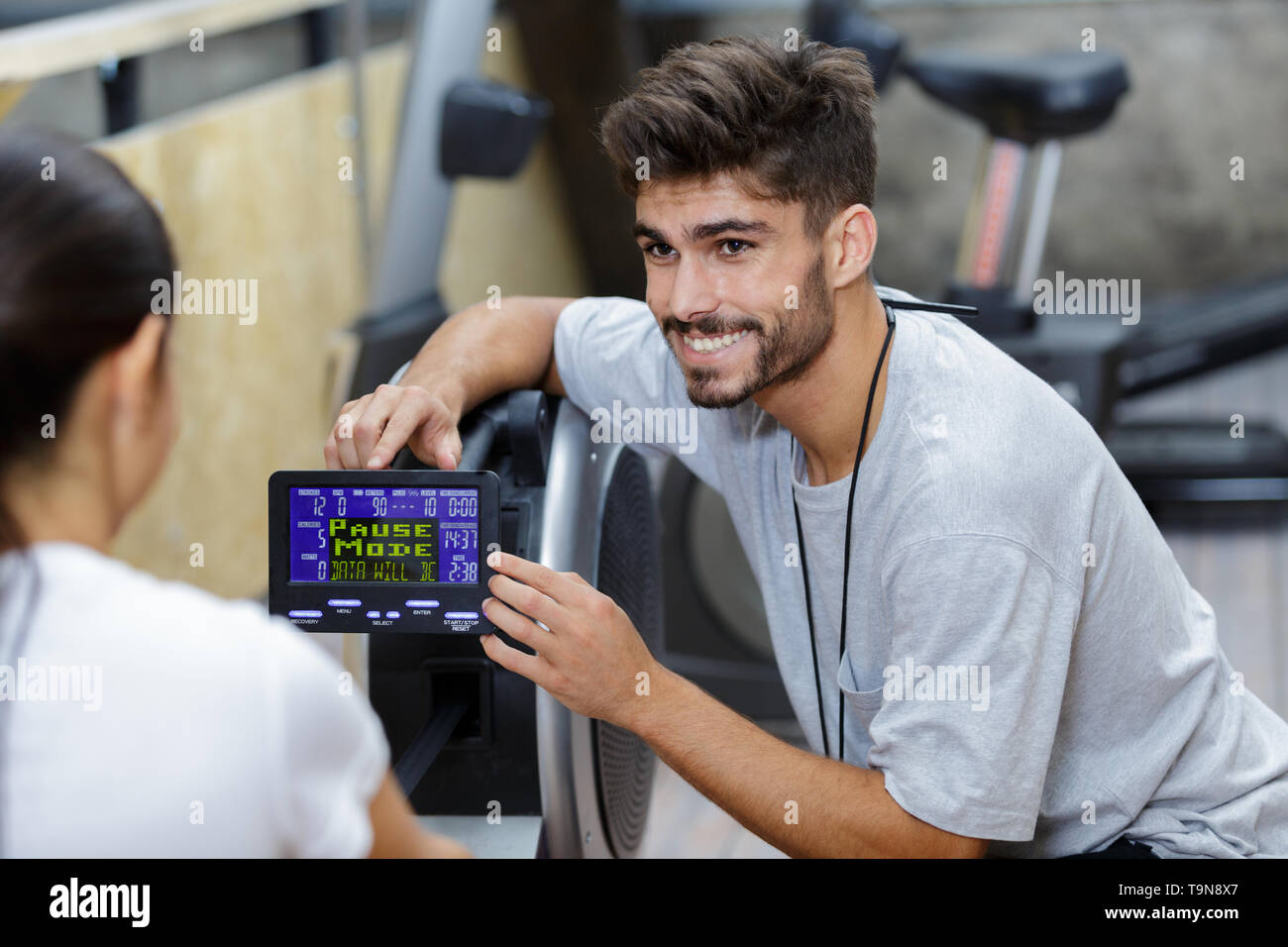 handsome coach training woman on the exercise rowing machine Stock ...