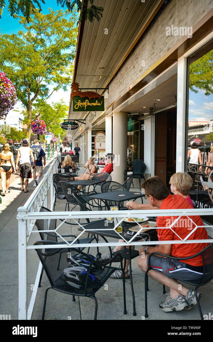 Summer tourists enjoy sidewalk dining and people watching in the Northern Idaho Alpine Lake town of  Coeur d'Alene, ID Stock Photo