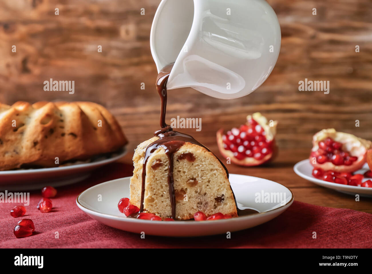 Pouring of chocolate sauce from jug onto Christmas cake Stock Photo Alamy