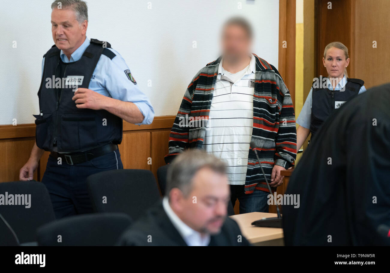 Hagen, Germany. 20th May, 2019. The defendant is escorted to the courtroom  of the Regional Court by judicial staff. The leading member of the rocker  club "Freeway Riders MC" is accused of