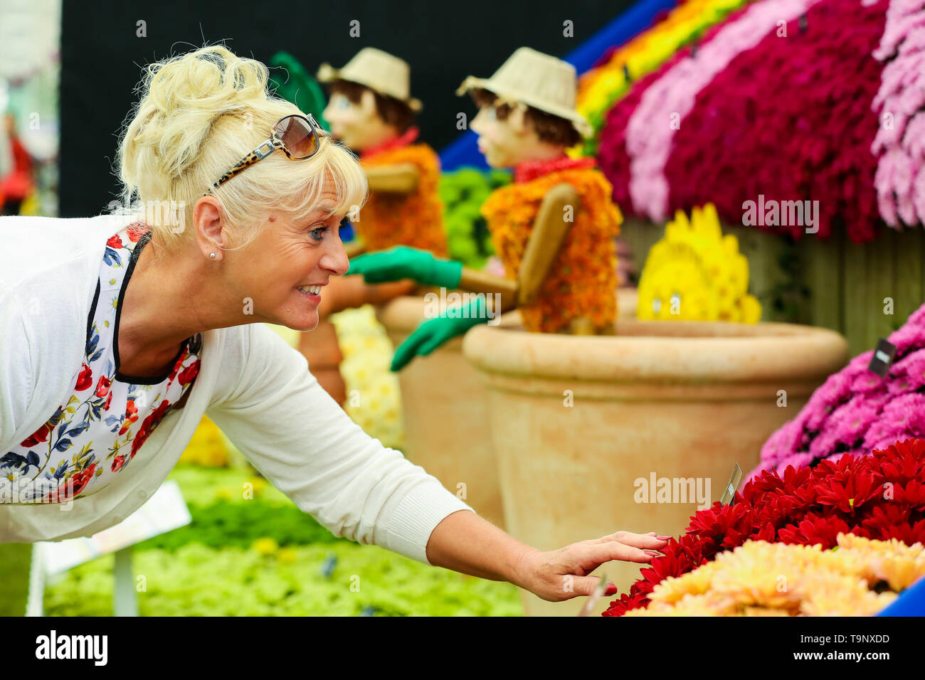 Royal Hospital Chelsea. West London, UK. 20th May, 2019. A woman puts finishing touches to Bill and Ben - the Flower Pot Men. The Royal Horticultural Society Chelsea Flower Show is an annual garden show held over five days in the grounds of the Royal Hospital Chelsea in West London. The show is open to the public from 21 May until 25 May 2019. Credit: Dinendra Haria/Alamy Live News Stock Photo