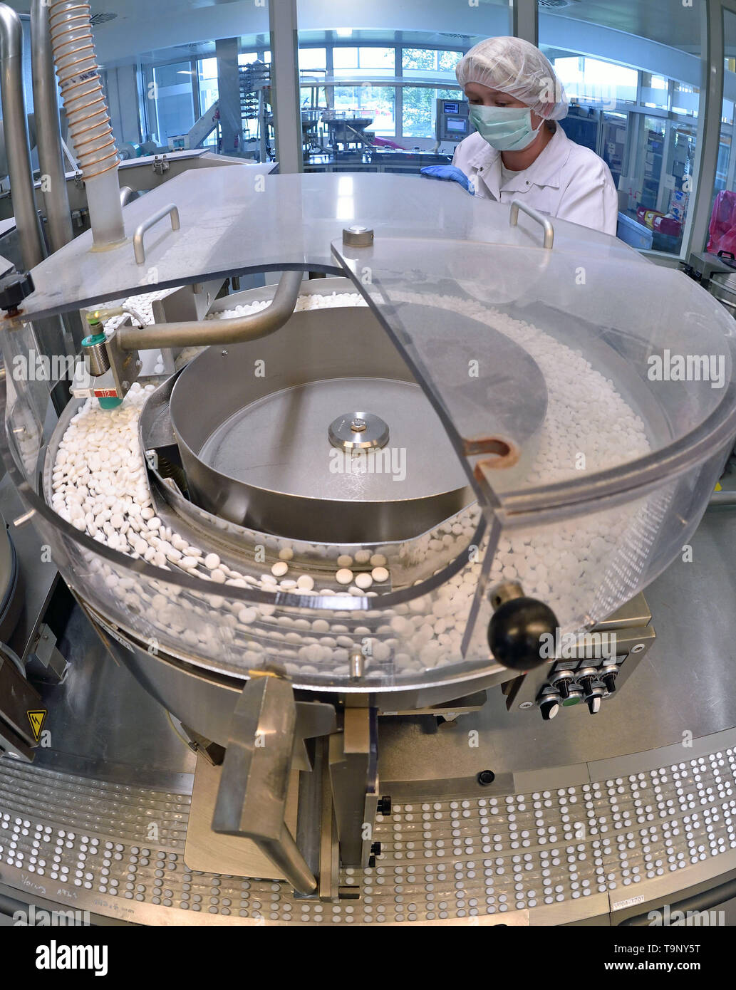 Bitterfeld Wolfen, Germany. 26th Aug, 2015. An employee at Bayer Bitterfeld  GmbH is working on a packaging line for aspirin tablets. While the global  market leaders from the USA and Switzerland were