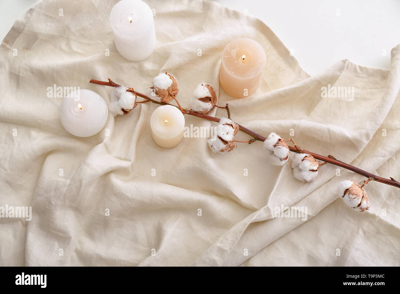 Burning candles and cotton flowers on soft fabric, top view Stock Photo ...