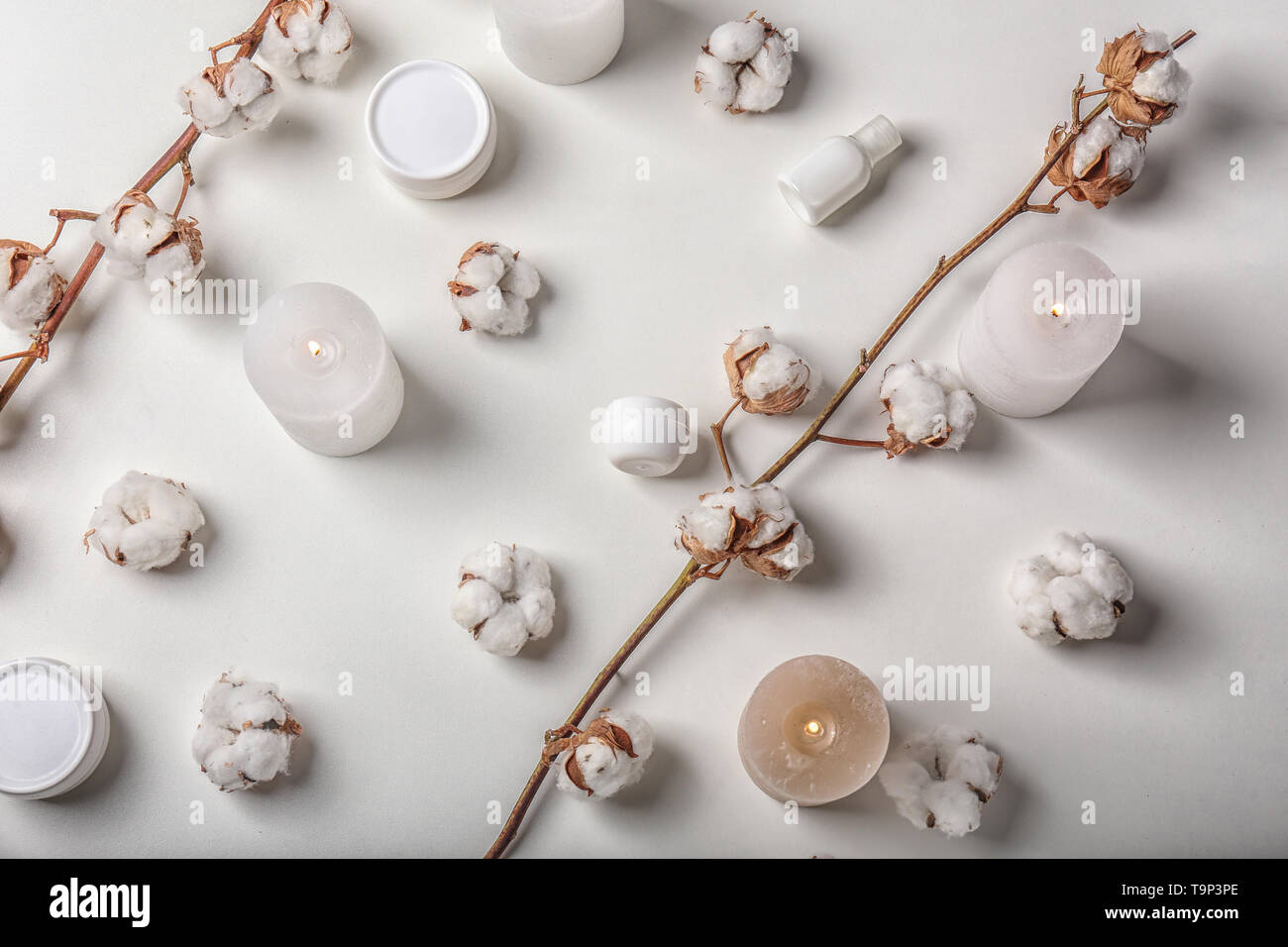 Flat lay composition with burning candles, cotton flowers and cosmetics ...