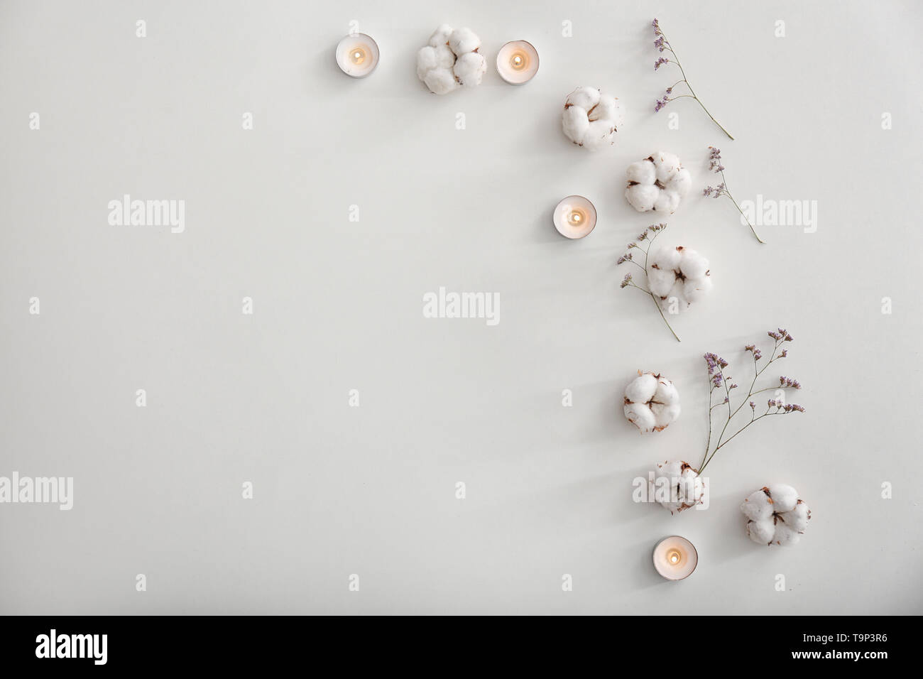 Flat lay composition with burning candles and cotton flowers on white ...
