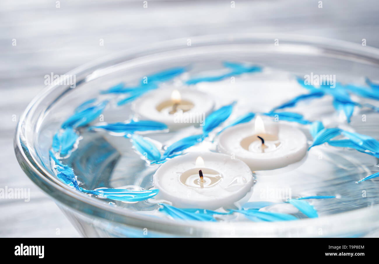 Glass bowl with floating candles and flower petals, closeup Stock Photo ...