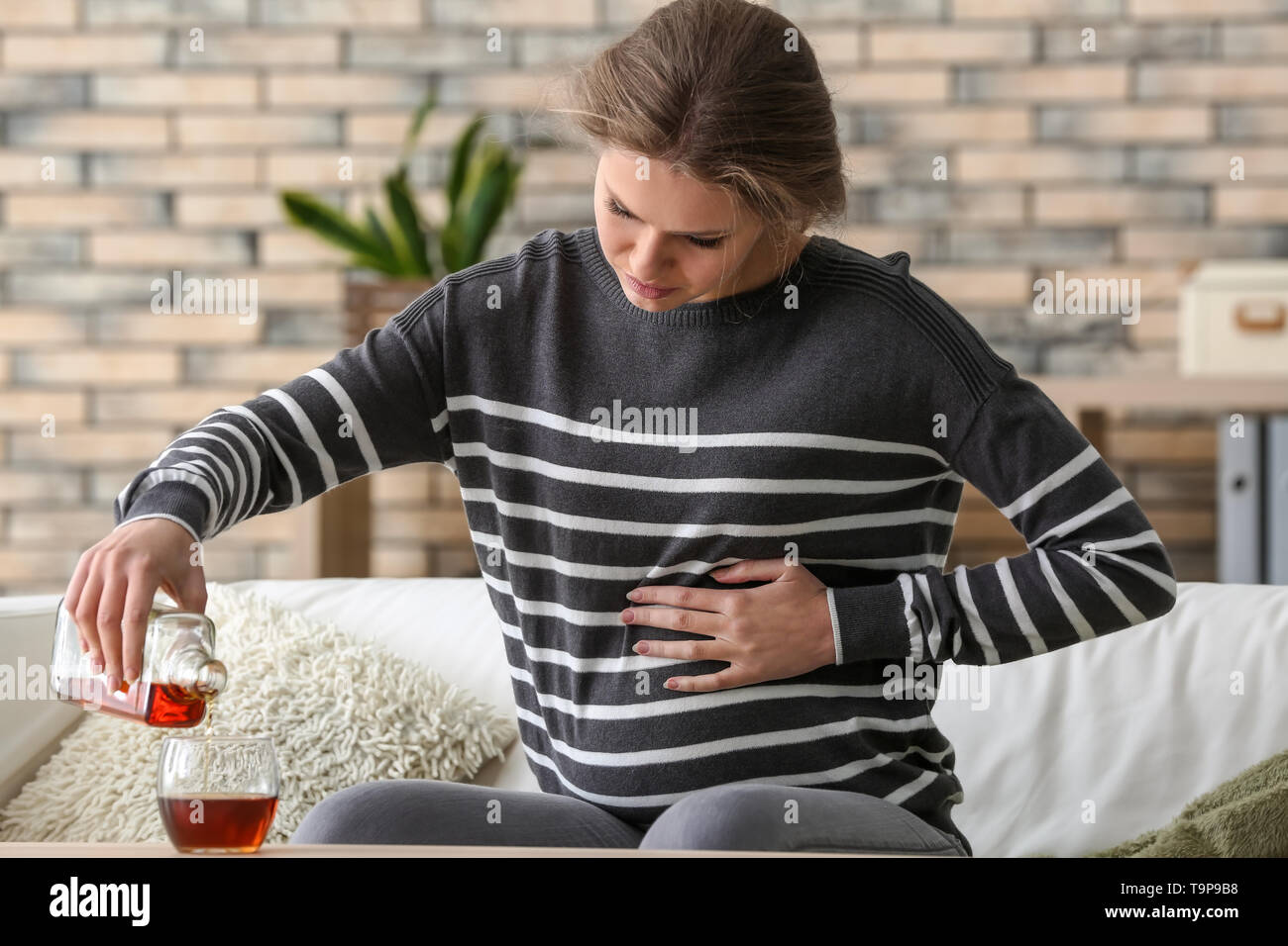 Pregnant woman drinking alcohol at home Stock Photo